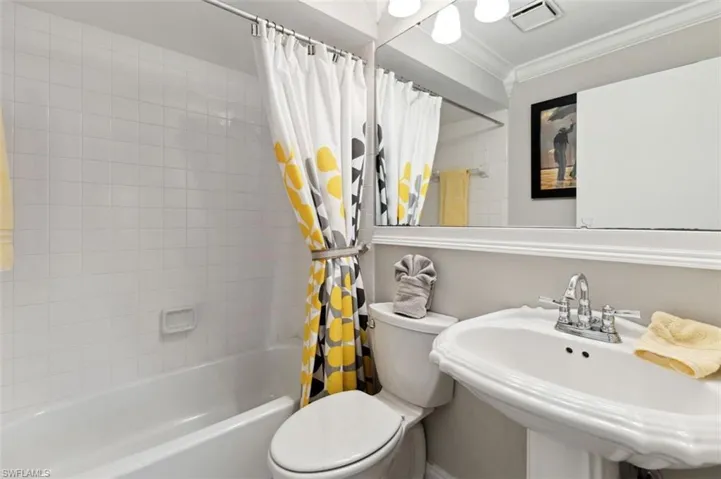 Full Guest bathroom featuring ornamental molding, toilet, shower / tub combo, and sink