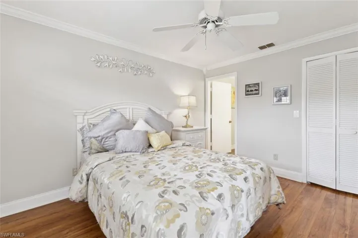 Master Bedroom featuring crown molding, dark hardwood / wood-style flooring, ceiling fan, and a closet
