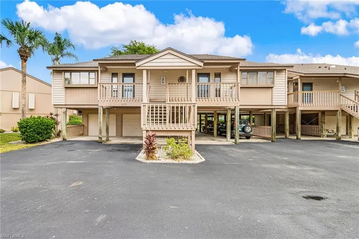 View of front of property with a residential view, stairway, a shingled roof, and driveway