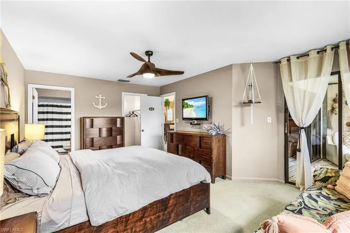 Bedroom featuring carpet, a ceiling fan, ensuite bathroom, and access to outside