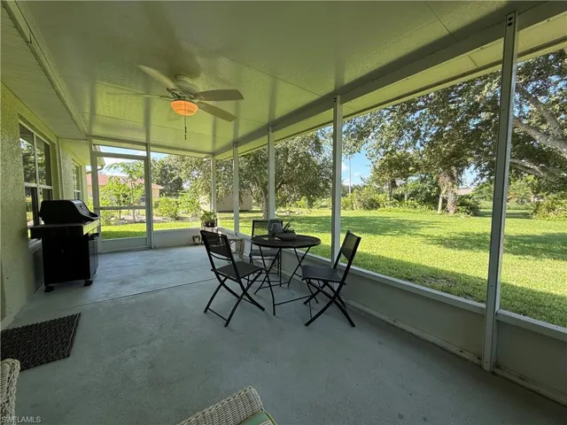 Sunroom / solarium with a ceiling fan and outdoor dining area