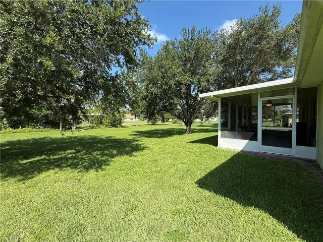 View of green lawn with a sunroom