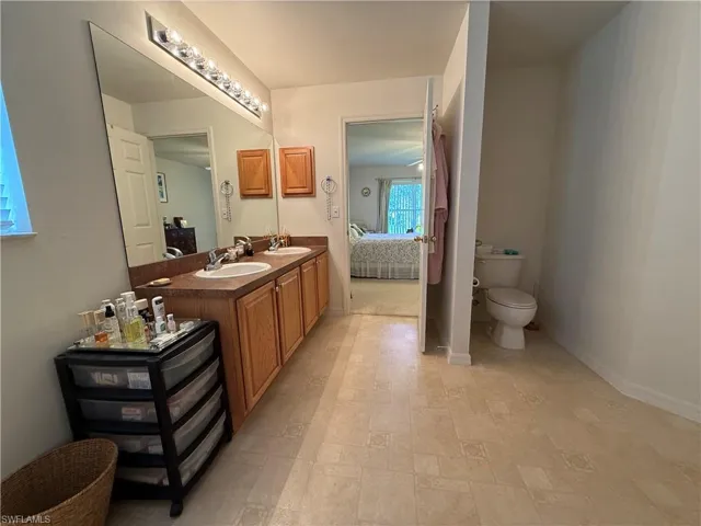 Ensuite bathroom with double vanity and stone finish flooring