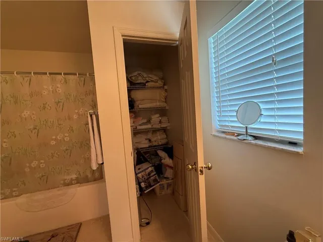 Bathroom featuring shower / bathtub combination with curtain and tile patterned flooring