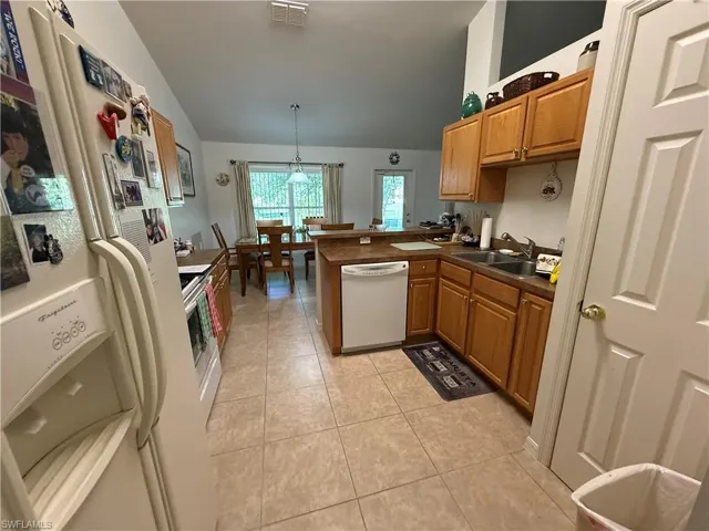 Living room with lofted ceiling, carpet flooring, and a ceiling fan
