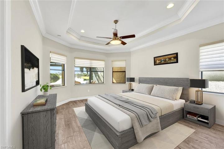 Primary bedroom with open water views, tray ceilings, crown molding and an en suite bathroom!