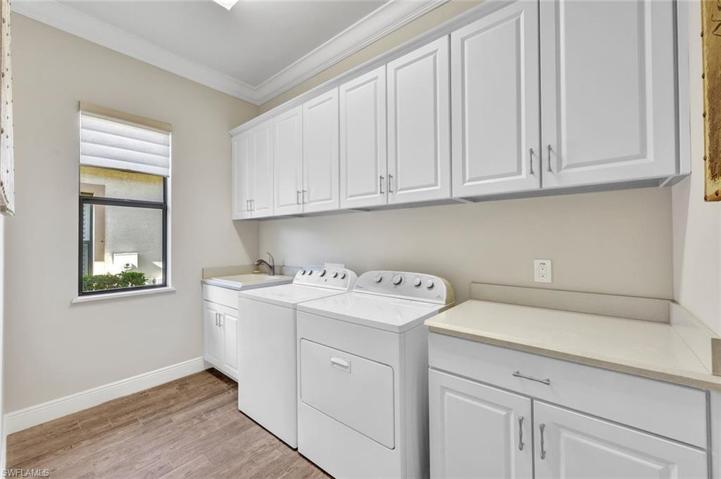 Spacious indoor utility room with ample storage space, folding counter, sink and window!
