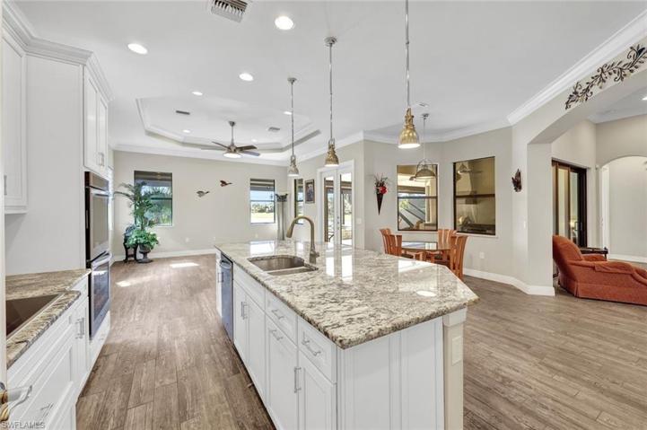 Gorgeous light and bright kitchen open to living spaces with sink in kitchen island and room for guests to sit. Tasteful pendant lighting with recessed lights and crown molding throughout!