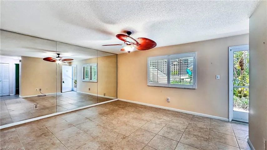 Unfurnished room with tile patterned floors, a textured ceiling, and ceiling fan