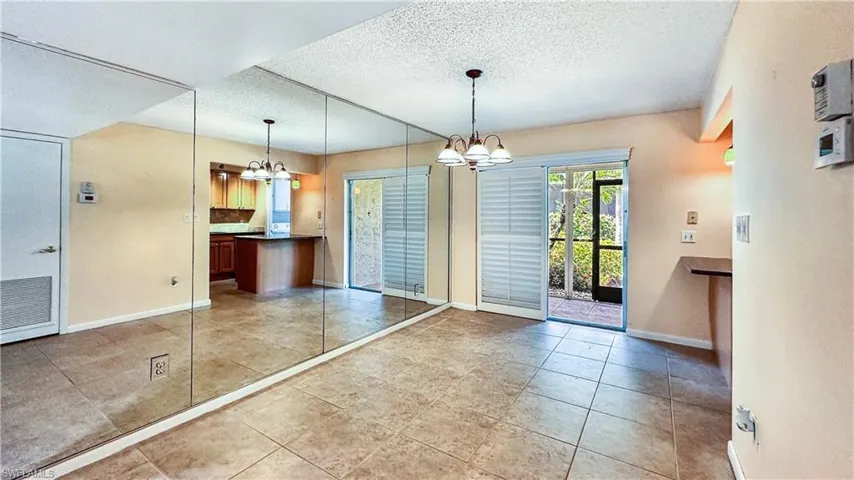 Unfurnished dining area featuring a chandelier, tile patterned flooring, and a textured ceiling