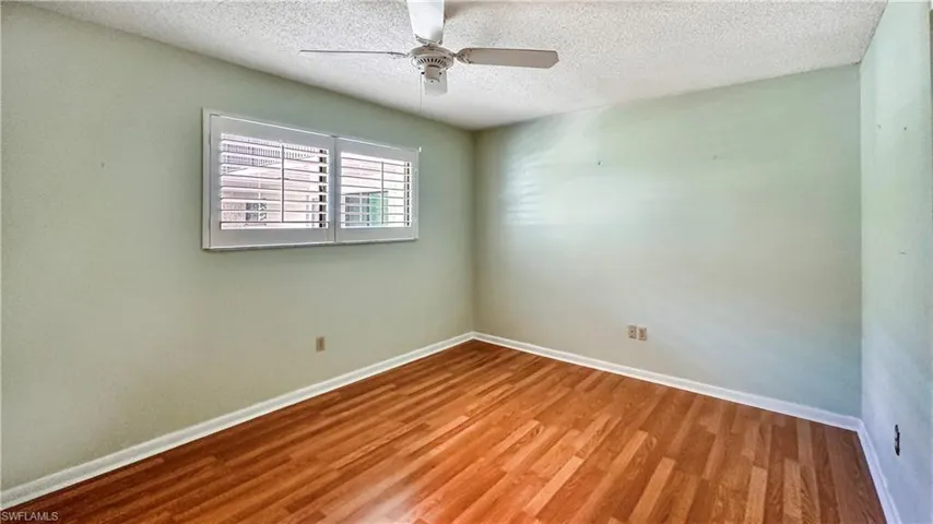 Unfurnished room with a textured ceiling, wood-type flooring, and ceiling fan