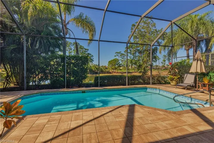 Outdoor pool featuring a sunroom and glass enclosure