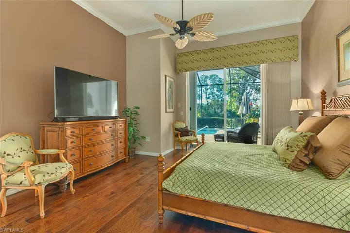 Bedroom featuring dark wood-type flooring, crown molding, access to exterior, a ceiling fan, and a sunroom