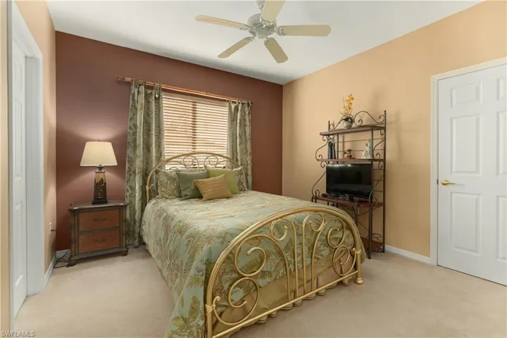 Carpeted bedroom featuring a ceiling fan and baseboards