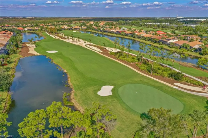 Aerial perspective of suburban area with a golf course and a nearby body of water