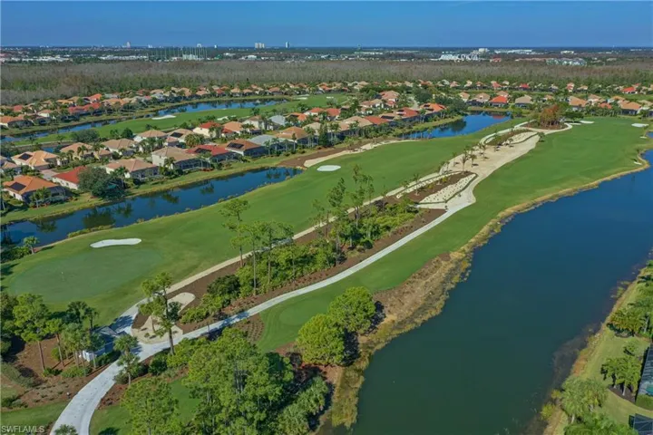 Aerial perspective of suburban area with a local golf course and a large body of water
