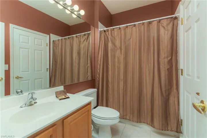 Bathroom with vanity, curtained shower, and light tile patterned floors