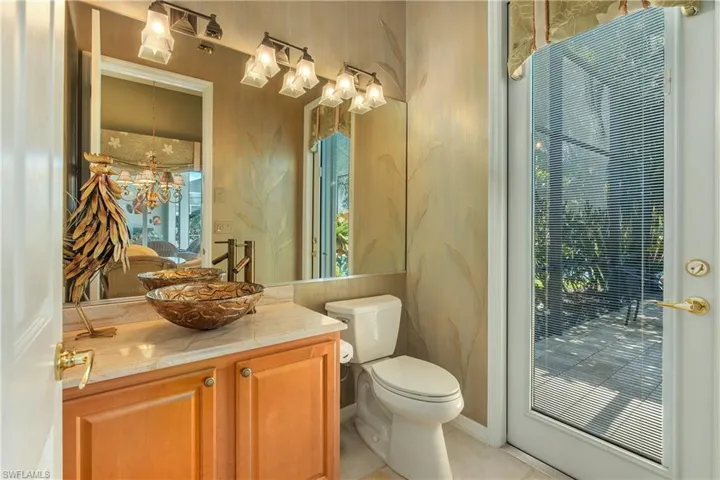 Bathroom featuring wallpapered walls and vanity
