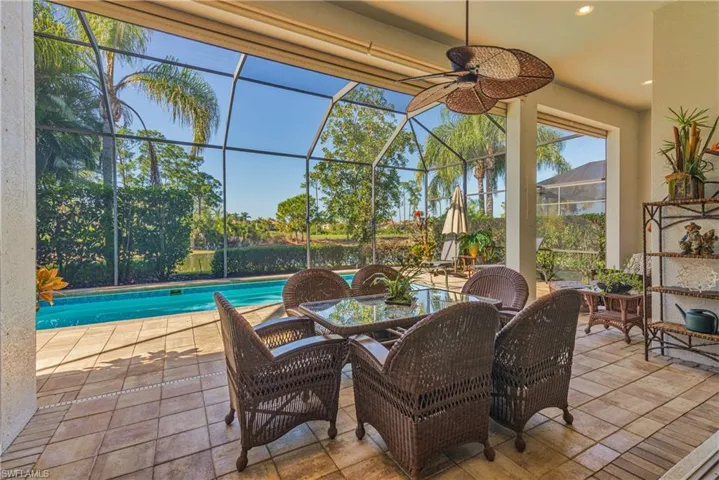 View of patio / terrace featuring ceiling fan, a sunroom, an outdoor pool, glass enclosure, and outdoor dining area