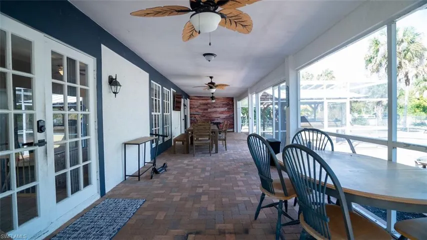 Sunroom with outdoor dining space, french doors, and ceiling fan