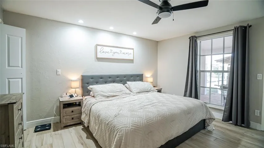Bedroom featuring light wood-style flooring, a textured wall, a ceiling fan, and recessed lighting