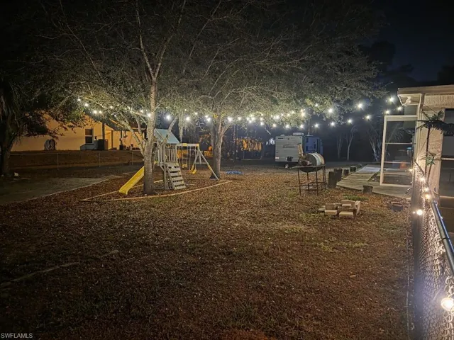 Yard at night featuring a playground