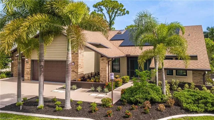 View of front of home featuring a garage and solar panels
