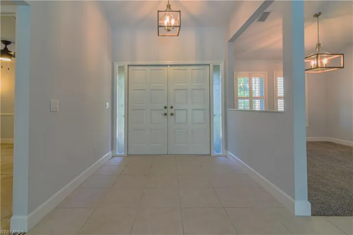 Tiled foyer with a notable chandelier