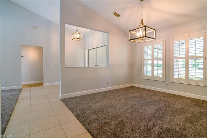 2 of 3 Versatile Living Spaces with impact glass windows and plantation shutters, chandelier.