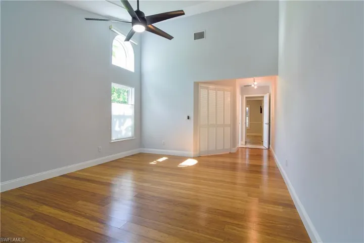 Primary bedroom with impact glass window, transom, and custom blinds.
