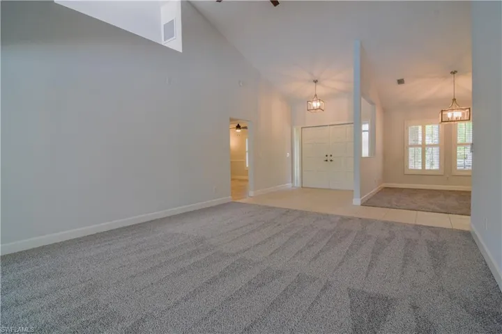 1 of 3 Versatile living spaces featuring carpet flooring, ceiling fan, high vaulted ceiling, and skylight.