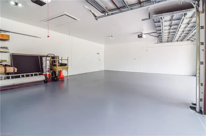 3 bay Garage featuring pull down staircase, fresh paint.