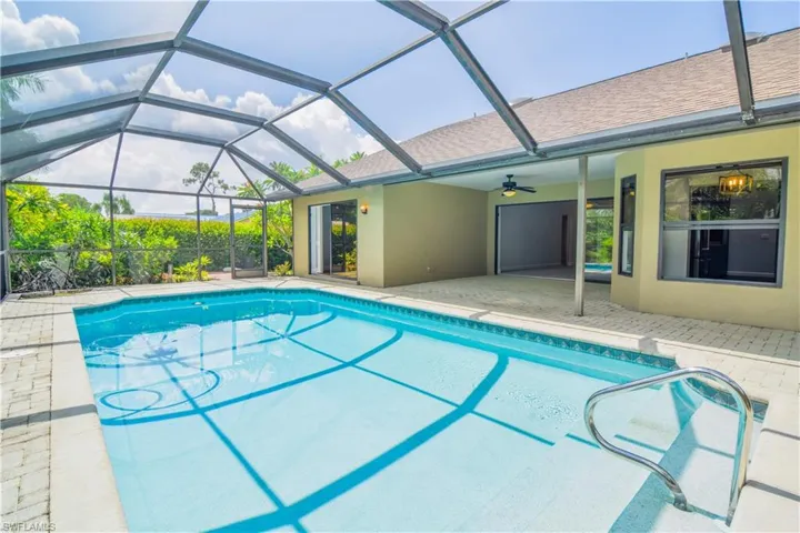 View of pool with a lanai, and 14' broad stairs into pool.