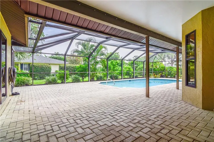 View of swimming pool with a pavered patio area and a lanai.