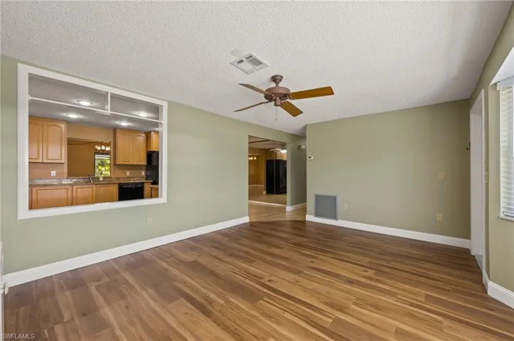 Unfurnished living room featuring wood-type flooring, a textured ceiling, ceiling fan, and sink