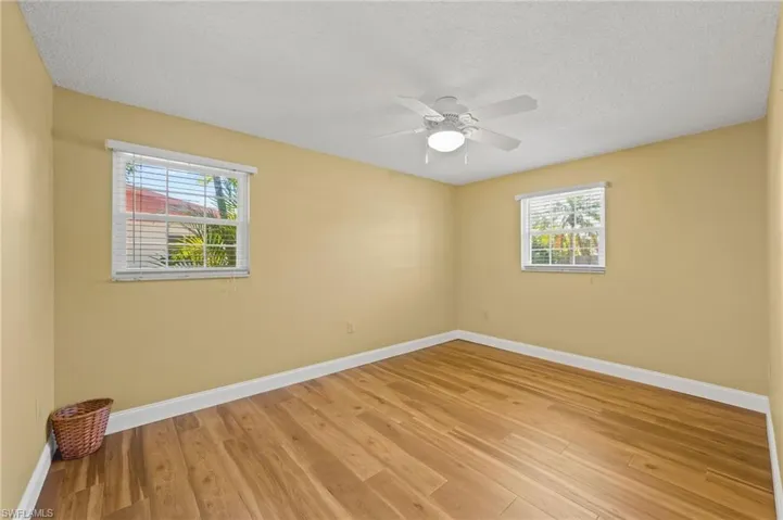 Unfurnished room with ceiling fan, a textured ceiling, and light hardwood / wood-style flooring