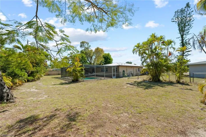 View of yard with a fenced in pool and a lanai