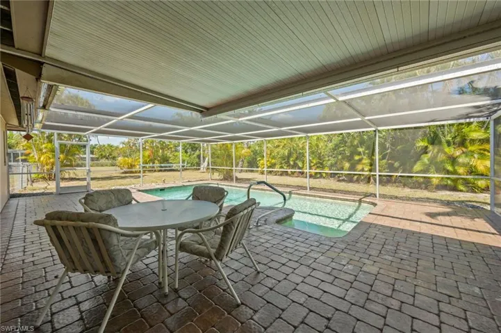View of pool with a lanai and a patio