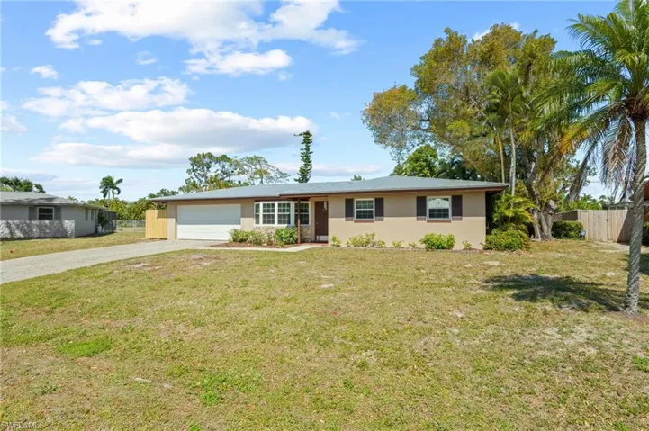 Ranch-style home with a front lawn and a garage