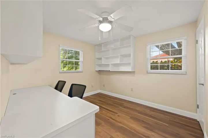 Home office featuring dark hardwood / wood-style flooring, a wealth of natural light, and ceiling fan