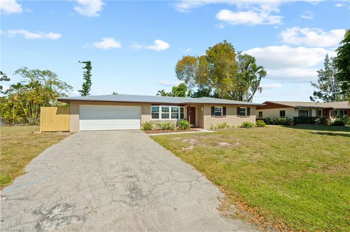 Ranch-style house with a front lawn and a garage