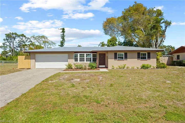 Ranch-style house featuring a front yard and a garage
