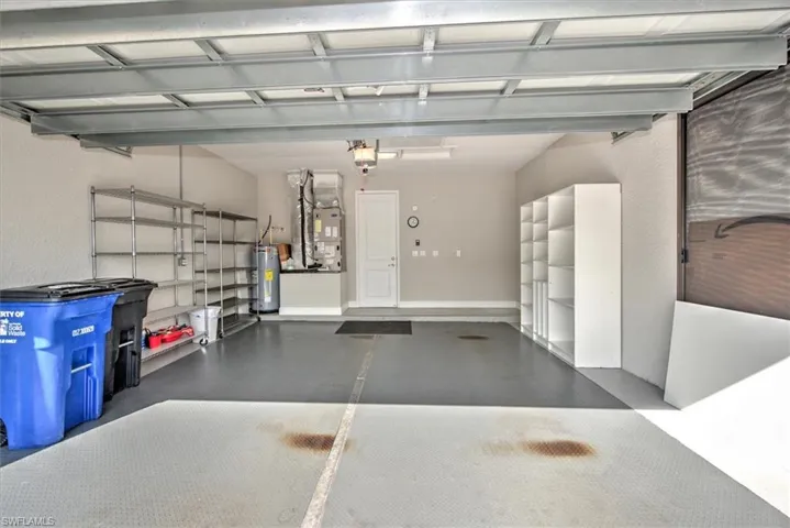 Garage featuring heating unit, water heater, and a garage door opener