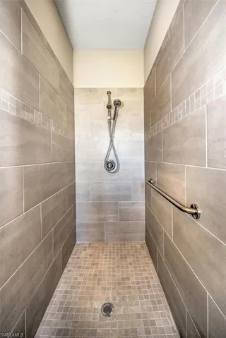 Bathroom featuring a textured ceiling and a tile shower