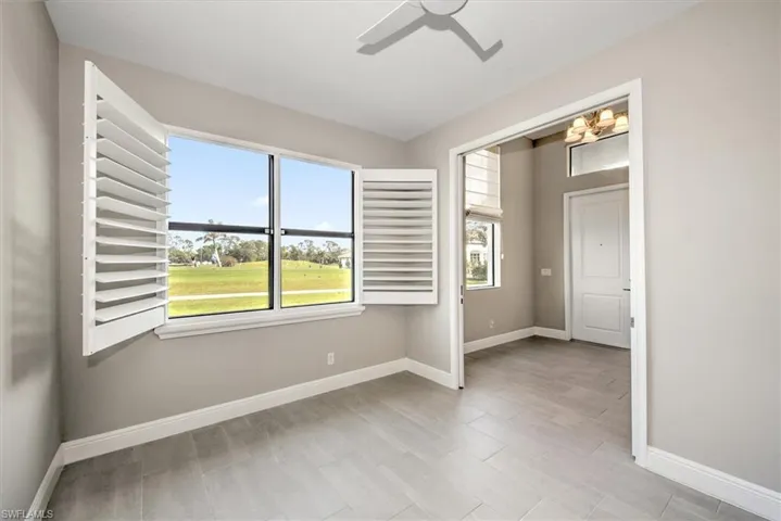 Spare room featuring ceiling fan with notable chandelier
