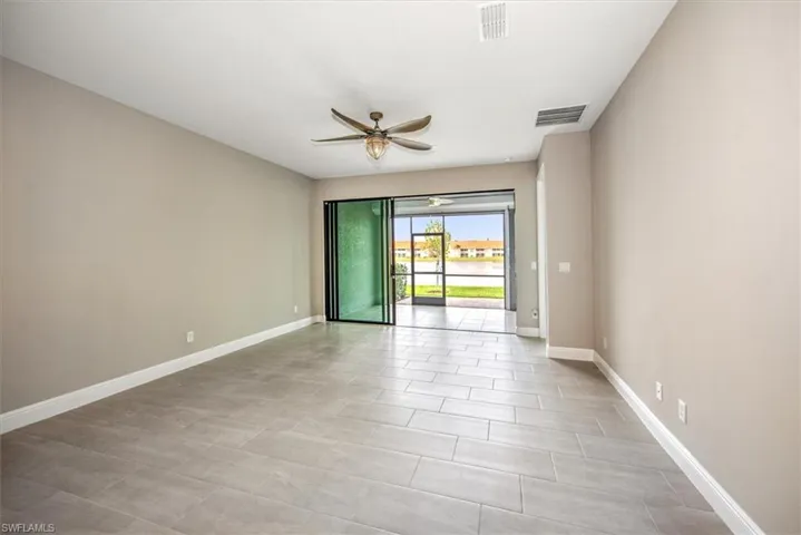 Tiled spare room featuring ceiling fan