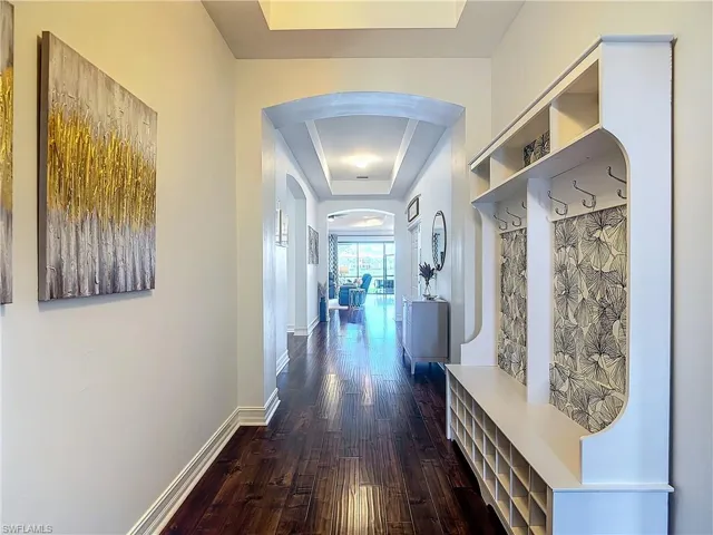 Corridor featuring a raised ceiling and dark hardwood / wood-style floors