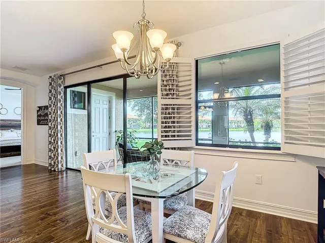Dining room with dark hardwood / wood-style floors and an inviting chandelier
