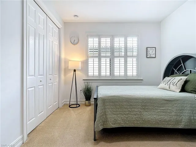 Carpeted bedroom with a closet