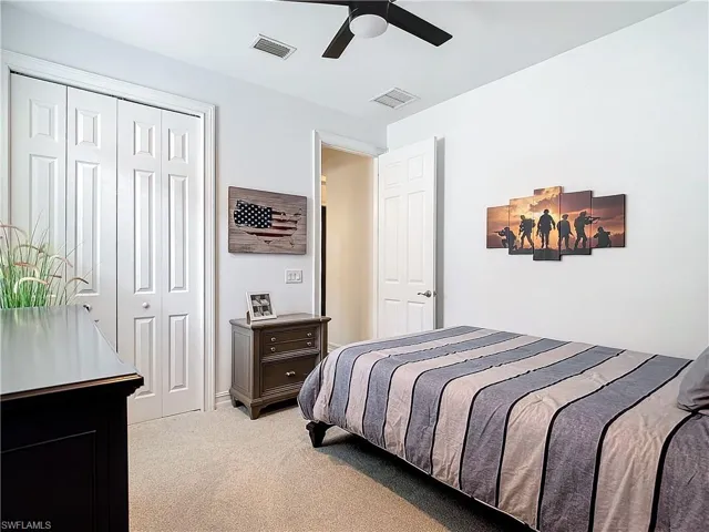 Bedroom with light carpet, a closet, and ceiling fan